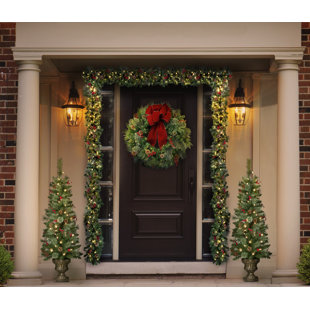 THREE POSTS™ Pair of 4' Potted Spruce Trees, 24 inch Classic Christmas Wreath, and Set of Two 9' Pre-Lit Garland