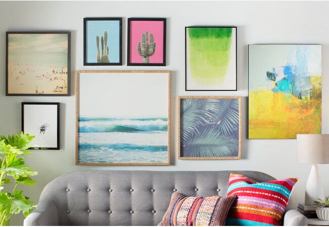 gallery wall made up of different sizes of brightly colored wall art