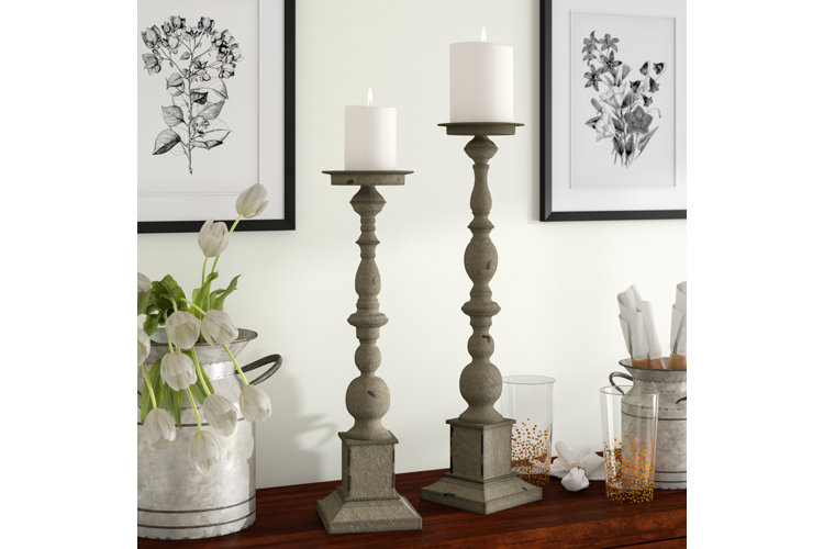 elegant candlesticks holding two thick white candles