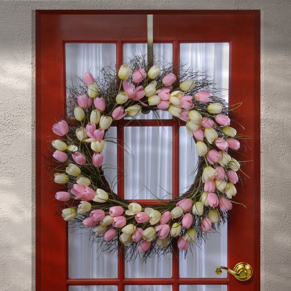 Handmade Wreath which pops with purple and pink flowers sitting on a background of purple and pink ribbon