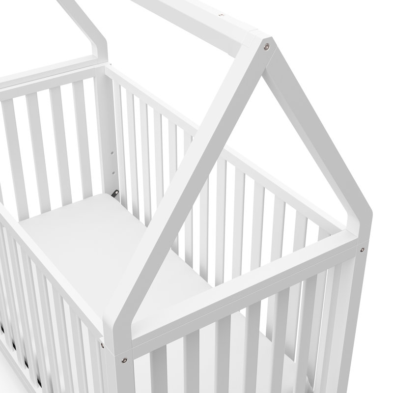 white swinging crib with drapes