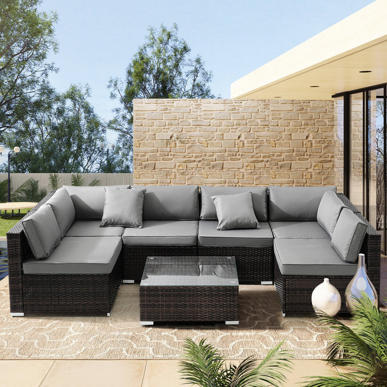 Gidja 110'' Wide Outdoor Wicker Patio Sofa with Cushions and End Table