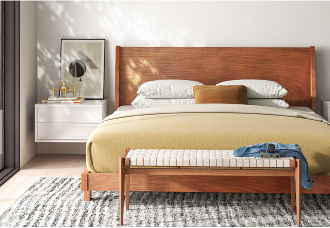 Picture of bedroom with large, wooden bed against the center of the wall.