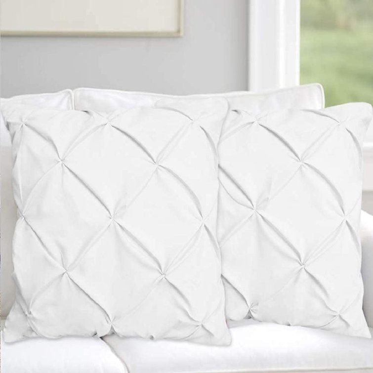 white bedding with throw pillows